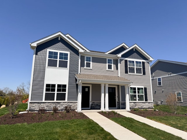 1100 58th Rd Unit 0020, Union Grove, WI 53182 - view of front facade with stone siding and a front lawn