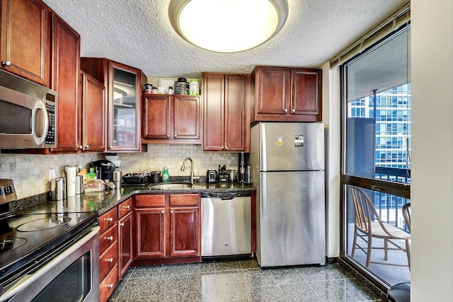 33 W Delaware Pl Unit 13A, Chicago, IL 60610 - kitchen with appliances with stainless steel finishes, a textured ceiling, reddish brown cabinets, granite floors, and backsplash