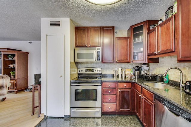 33 W Delaware Pl Unit 13A, Chicago, IL 60610 - kitchen with stainless steel appliances, tasteful backsplash, glass insert cabinets, a textured ceiling, and granite tiled floors