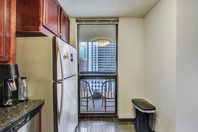 33 W Delaware Pl Unit 13A, Chicago, IL 60610 - kitchen featuring reddish brown cabinets, freestanding refrigerator, granite floors, a textured ceiling, and dark stone counters