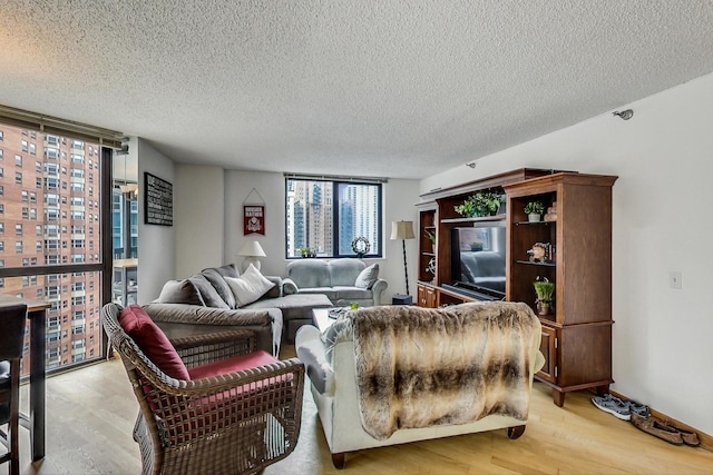 33 W Delaware Pl Unit 13A, Chicago, IL 60610 - living room featuring light wood finished floors, a wall of windows, and a textured ceiling