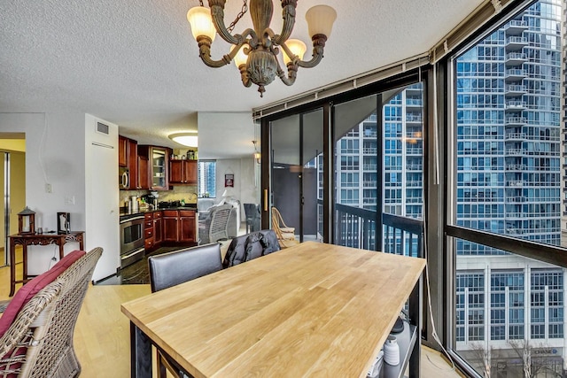 33 W Delaware Pl Unit 13A, Chicago, IL 60610 - dining room featuring expansive windows, a chandelier, a textured ceiling, and light wood-type flooring