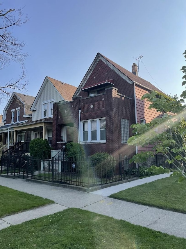 7240 S Lafayette Ave, Chicago, IL 60621 - view of front of home with a fenced front yard, brick siding, and a chimney