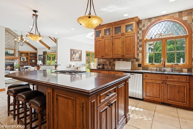 8S241 Dunham Dr, Naperville, IL 60540 - kitchen featuring stainless steel appliances, dark countertops, brown cabinetry, lofted ceiling, and a kitchen island