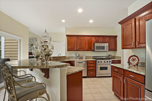 4 Shadow Creek Ct, Lake In The Hills, IL 60156 - kitchen with stainless steel appliances, a breakfast bar, light stone counters, light tile patterned flooring, and recessed lighting