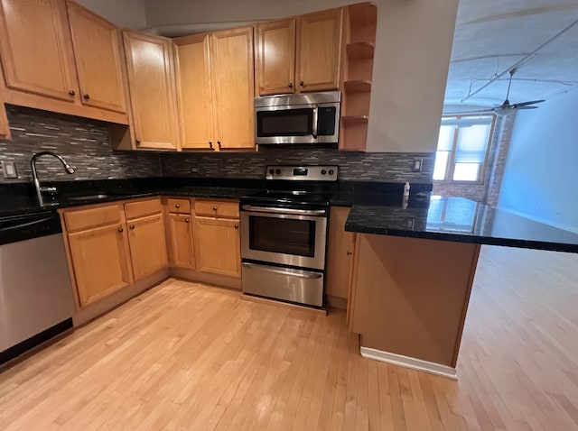 801 S Wells St Unit 303, Chicago, IL 60607 - kitchen with appliances with stainless steel finishes, a peninsula, light wood-type flooring, and backsplash