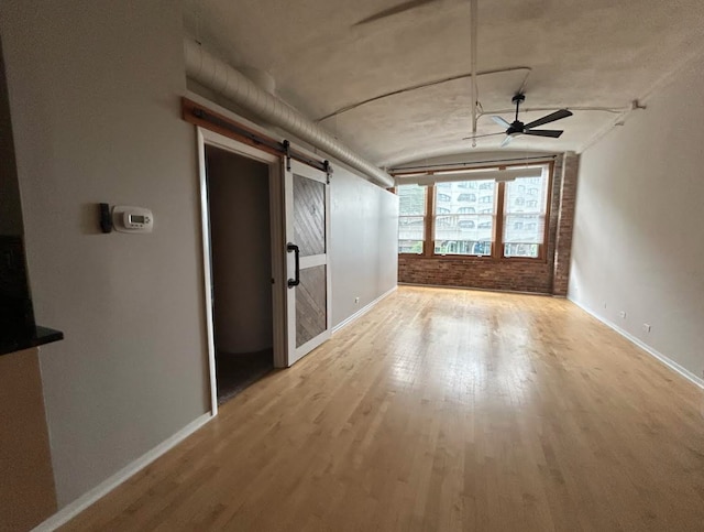 801 S Wells St Unit 303, Chicago, IL 60607 - empty room with a barn door, light wood finished floors, ceiling fan, and lofted ceiling