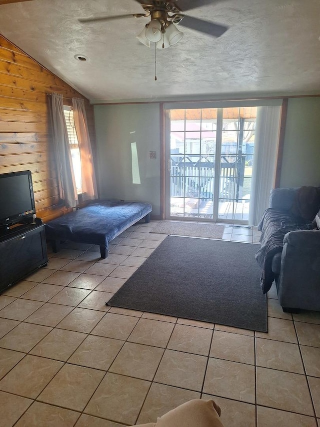 306 N Joy St, Tampico, IL 61283 - bedroom featuring light tile patterned floors, wood walls, a textured ceiling, a ceiling fan, and lofted ceiling