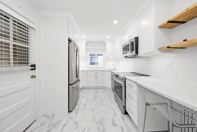 2228 Central St Unit 3, Evanston, IL 60201 - kitchen featuring stainless steel appliances, open shelves, light marble finish floors, white cabinetry, and recessed lighting
