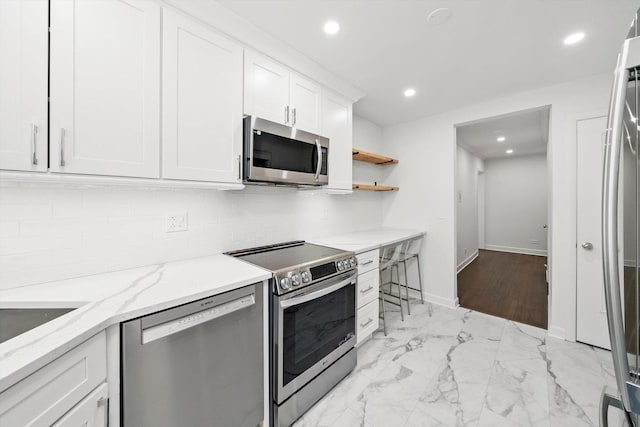 2228 Central St Unit 3, Evanston, IL 60201 - kitchen with appliances with stainless steel finishes, tasteful backsplash, white cabinetry, light marble finish floors, and recessed lighting