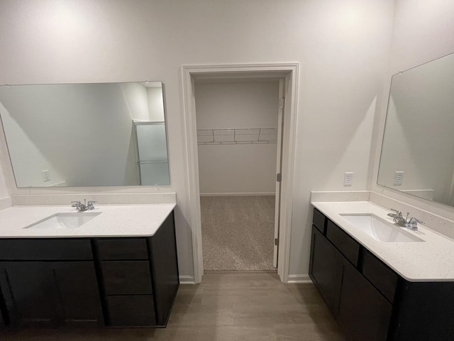 2522 Redwood Trl, Wonder Lake, IL 60097 - bathroom with two vanities, a walk in closet, and wood finished floors