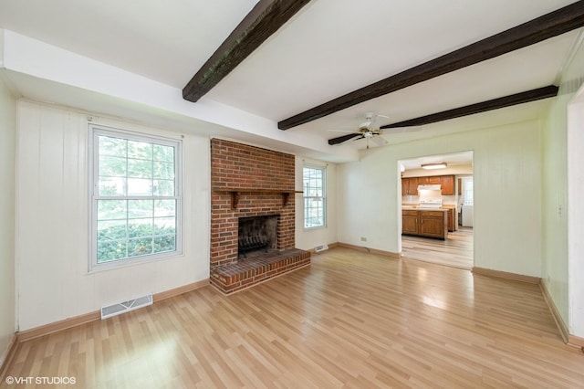 316 Ambleside Dr, Roselle, IL 60172 - unfurnished living room featuring light wood finished floors, beam ceiling, ceiling fan, and a fireplace
