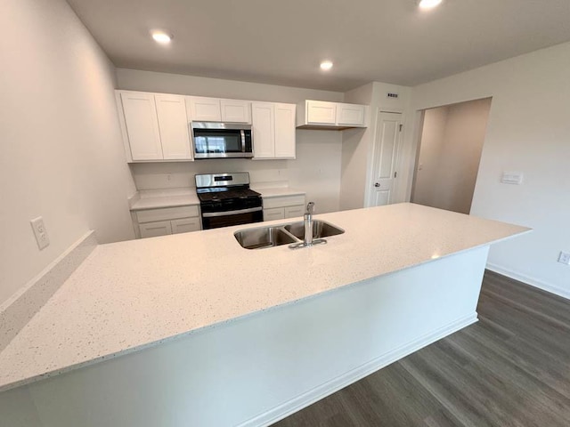 1052 58th Rd Unit 0021, Union Grove, WI 53182 - kitchen featuring appliances with stainless steel finishes, white cabinetry, dark wood finished floors, recessed lighting, and light stone counters