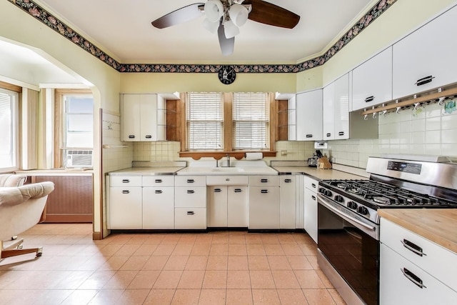 6339 S Kostner Ave, Chicago, IL 60629 - kitchen with stainless steel range with gas stovetop, ceiling fan, backsplash, white cabinetry, and cooling unit
