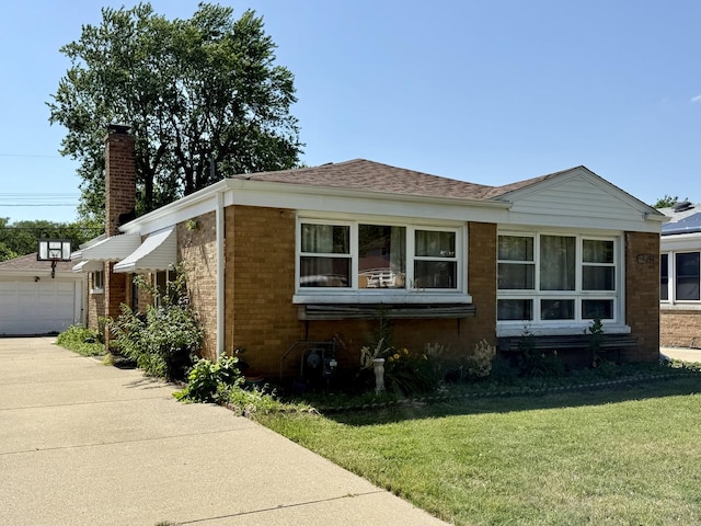 9424 Lorel Ave, Skokie, IL 60077 - view of front of house with brick siding, a front lawn, driveway, and a detached garage