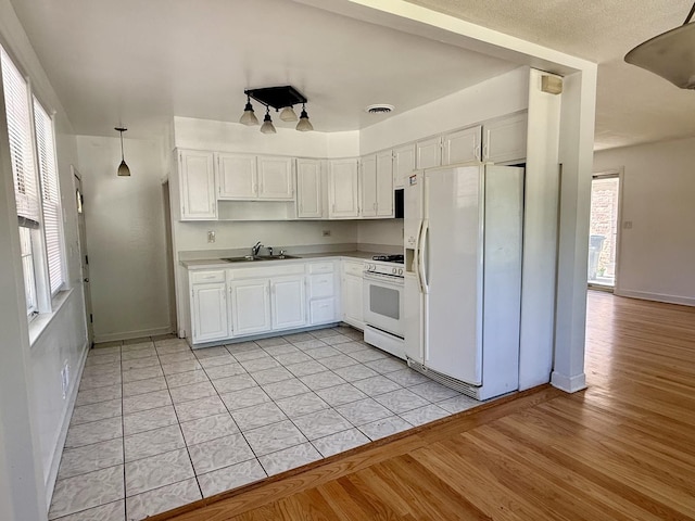 9424 Lorel Ave, Skokie, IL 60077 - kitchen featuring white appliances, white cabinetry, light wood-style flooring, and light countertops
