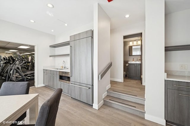 1440 N State Pkwy Unit 21C, Chicago, IL 60610 - kitchen featuring built in refrigerator, open shelves, modern cabinets, light countertops, and light wood-type flooring