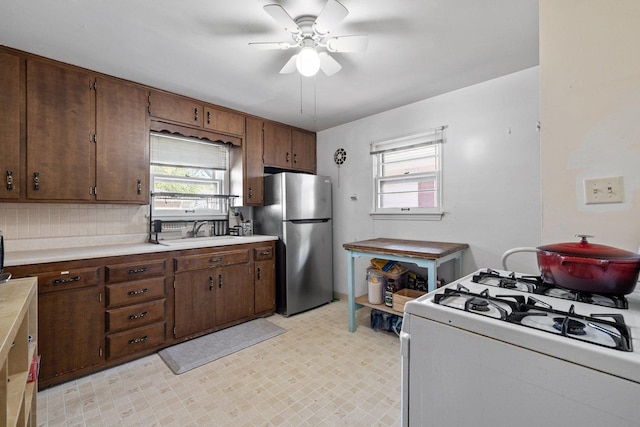 517 N William St, Joliet, IL 60435 - kitchen with white gas range, freestanding refrigerator, a ceiling fan, and light countertops