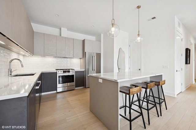 2405 W Iowa St Unit 206, Chicago, IL 60622 - kitchen featuring appliances with stainless steel finishes, gray cabinetry, light wood finished floors, and tasteful backsplash