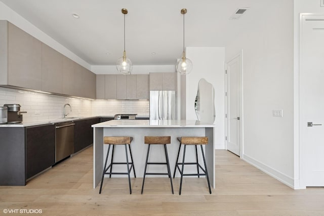 2405 W Iowa St Unit 206, Chicago, IL 60622 - kitchen featuring appliances with stainless steel finishes, a kitchen breakfast bar, modern cabinets, and tasteful backsplash