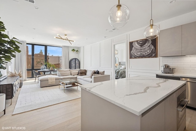 2405 W Iowa St Unit 206, Chicago, IL 60622 - kitchen with floor to ceiling windows, stainless steel dishwasher, a center island, light wood finished floors, and open floor plan