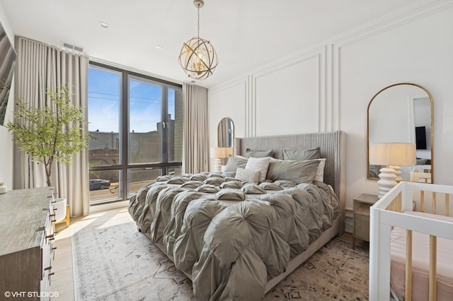 2405 W Iowa St Unit 206, Chicago, IL 60622 - bedroom with expansive windows, a chandelier, and light wood finished floors