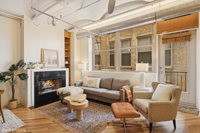 500 S Clinton St Unit 517, Chicago, IL 60607 - living area featuring wood finished floors, track lighting, built in features, and a fireplace with flush hearth