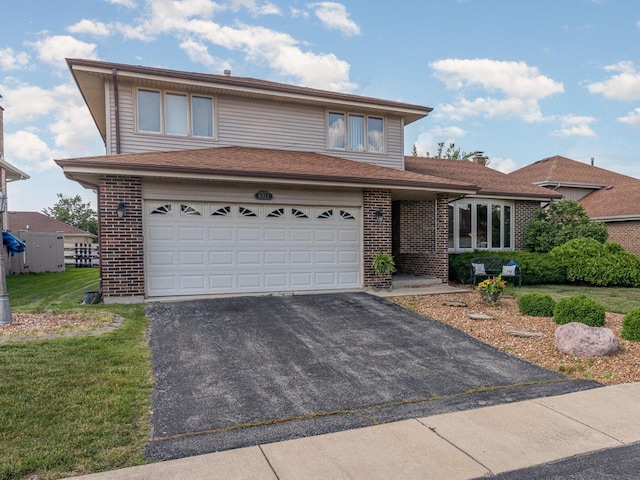 8712 Carriage Ln, Tinley Park, IL 60487 - traditional-style house with asphalt driveway, a garage, brick siding, and a front lawn