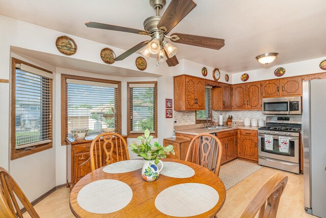 8712 Carriage Ln, Tinley Park, IL 60487 - kitchen with stainless steel appliances, backsplash, light countertops, ceiling fan, and brown cabinetry