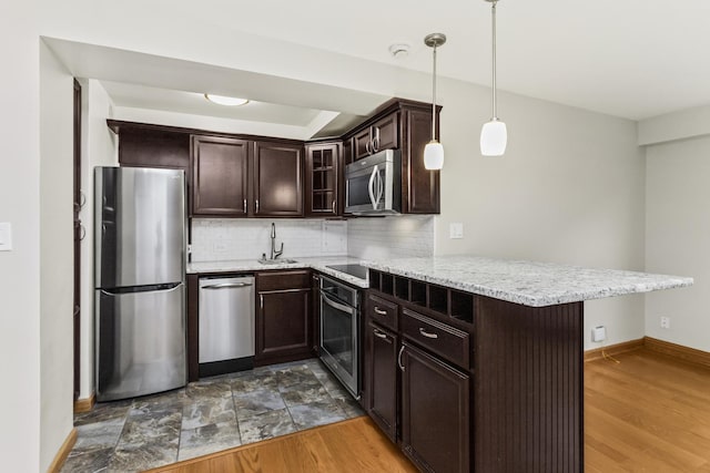 2909 N Sheridan Rd Unit 1601, Chicago, IL 60657 - kitchen with appliances with stainless steel finishes, a peninsula, dark brown cabinetry, backsplash, and glass insert cabinets