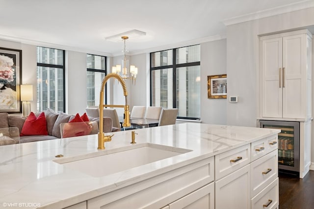 1122 N Dearborn St Unit 10A, Chicago, IL 60610 - kitchen featuring wine cooler, light stone countertops, ornamental molding, white cabinets, and a chandelier