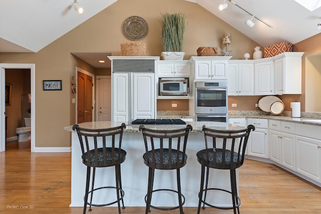 17 Ruffled Feathers Dr, Lemont, IL 60439 - kitchen featuring built in appliances, track lighting, a kitchen bar, a center island, and white cabinets