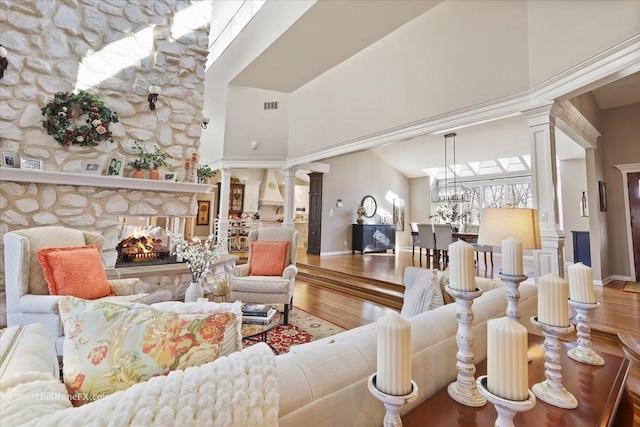 1417 Sherwood Ln, Geneva, IL 60134 - living room with decorative columns, a towering ceiling, wood finished floors, a fireplace, and a chandelier