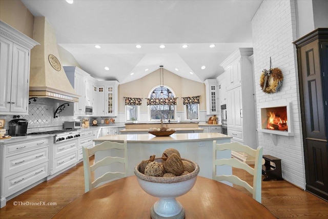 1417 Sherwood Ln, Geneva, IL 60134 - kitchen with a center island, lofted ceiling, light countertops, stainless steel gas cooktop, and glass insert cabinets