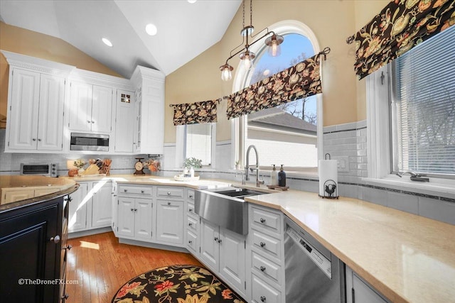 1417 Sherwood Ln, Geneva, IL 60134 - kitchen with stainless steel appliances, vaulted ceiling, light wood finished floors, decorative backsplash, and white cabinetry