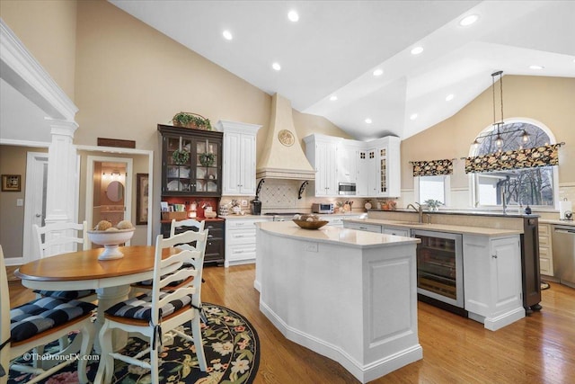 1417 Sherwood Ln, Geneva, IL 60134 - kitchen with wine cooler, a center island, high vaulted ceiling, custom exhaust hood, and light countertops