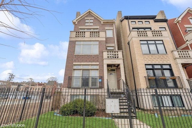 1449 E 65th Pl Unit 1, Chicago, IL 60637 - townhome / multi-family property featuring brick siding, a fenced front yard, and a gate