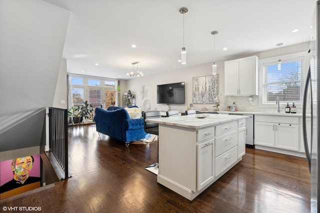 1449 E 65th Pl Unit 1, Chicago, IL 60637 - kitchen with appliances with stainless steel finishes, a kitchen island, white cabinetry, dark wood finished floors, and hanging light fixtures