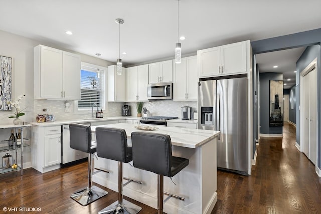 1449 E 65th Pl Unit 1, Chicago, IL 60637 - kitchen featuring stainless steel appliances, backsplash, white cabinets, dark wood-style flooring, and a center island