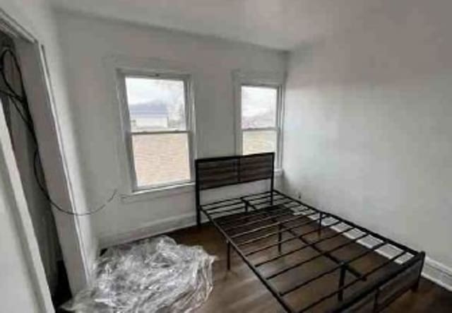 2626 W 96th Pl, Evergreen Park, IL 60805 - unfurnished bedroom featuring multiple windows and wood finished floors