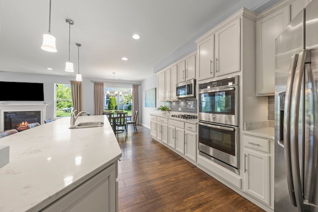 27W120 Timber Creek Dr, Winfield, IL 60190 - kitchen with stainless steel appliances, recessed lighting, backsplash, dark wood finished floors, and a glass covered fireplace