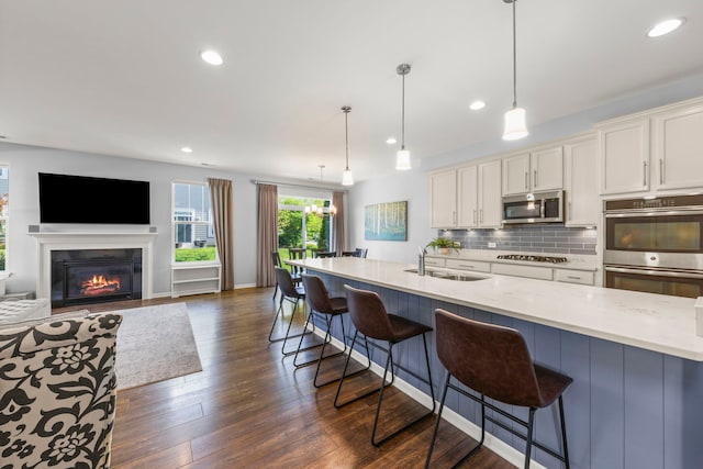 27W120 Timber Creek Dr, Winfield, IL 60190 - kitchen with stainless steel appliances, a kitchen breakfast bar, white cabinetry, decorative backsplash, and open floor plan