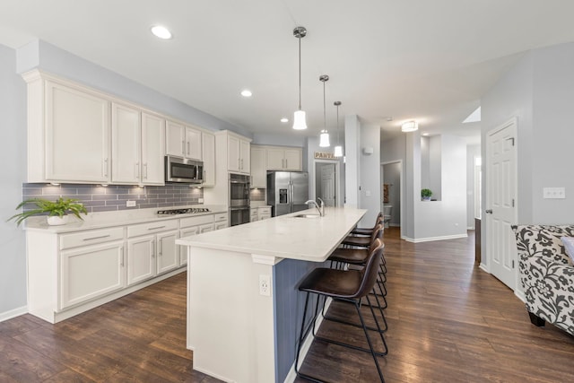 27W120 Timber Creek Dr, Winfield, IL 60190 - kitchen with appliances with stainless steel finishes, dark wood finished floors, backsplash, a breakfast bar, and recessed lighting