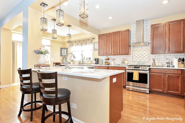 3123 Concord Ln, Wadsworth, IL 60083 - kitchen with gas stove, wall chimney exhaust hood, light wood-type flooring, light countertops, and recessed lighting