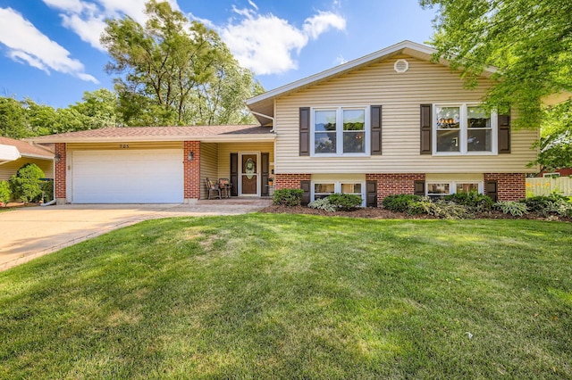 905 Harrison Ln, Hoffman Estates, IL 60192 - split level home featuring an attached garage, brick siding, driveway, and a front lawn