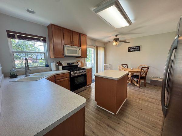 475 Lancaster Dr, Pingree Grove, IL 60140 - kitchen featuring stainless steel appliances, a center island, light wood-style floors, light countertops, and ceiling fan
