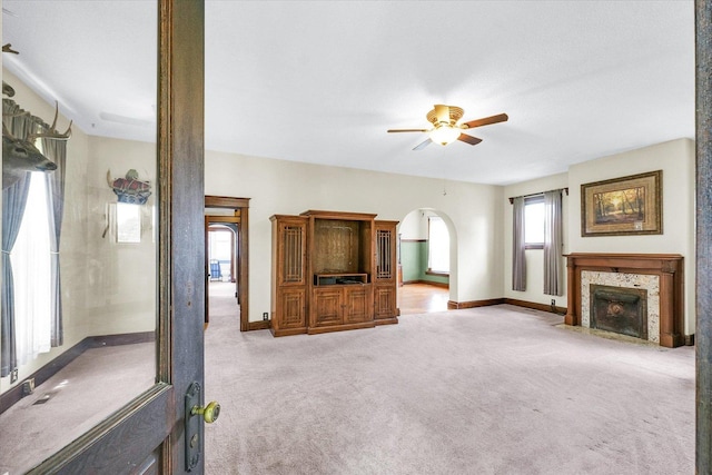 301 N Main St, Fithian, IL 61844 - unfurnished living room featuring ceiling fan, carpet floors, arched walkways, and a fireplace