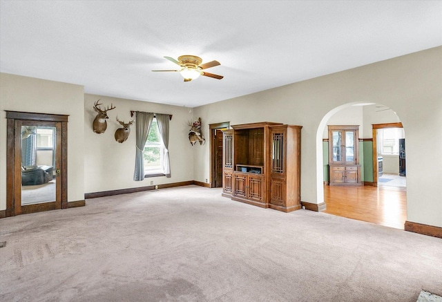 301 N Main St, Fithian, IL 61844 - unfurnished living room with light colored carpet, ceiling fan, and arched walkways