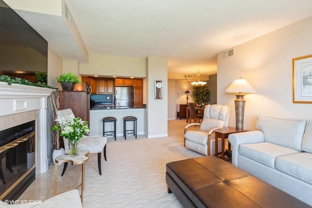 511 Aurora Ave Unit 405, Naperville, IL 60540 - living room featuring light carpet, a chandelier, and a glass covered fireplace