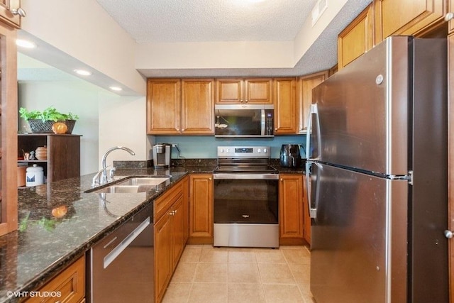 511 Aurora Ave Unit 405, Naperville, IL 60540 - kitchen featuring appliances with stainless steel finishes, brown cabinets, dark stone counters, light tile patterned flooring, and a textured ceiling